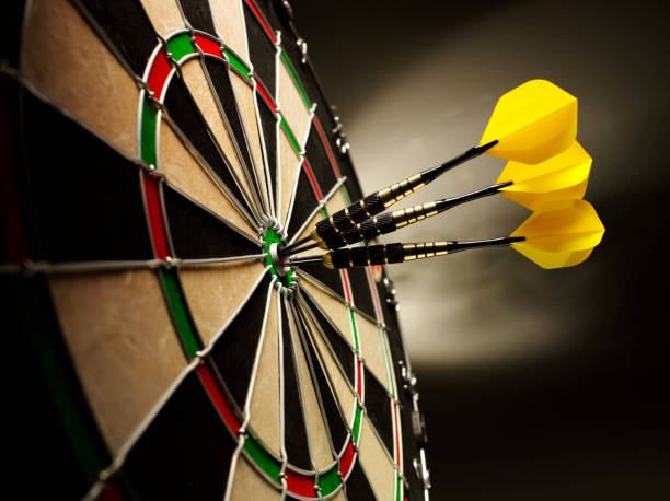 Darts on Target Three yellow darts hitting the target in a game of darts scoring a bulls eye.  dartboard stock pictures, royalty-free photos & images