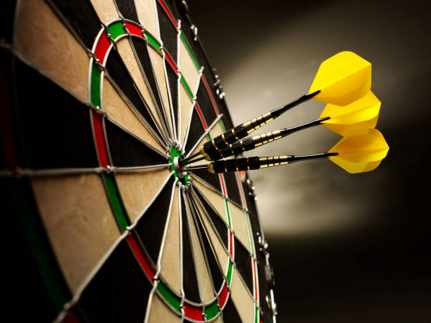 Darts on Target Three yellow darts hitting the target in a game of darts scoring a bulls eye. dart stock pictures, royalty-free photos & images