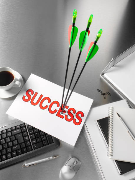 Three archery arrows in a success target sign, on a stainless steel office desk 