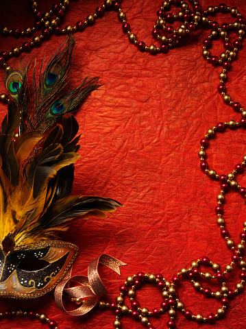Masquerade mask with copy space on a red texted background.