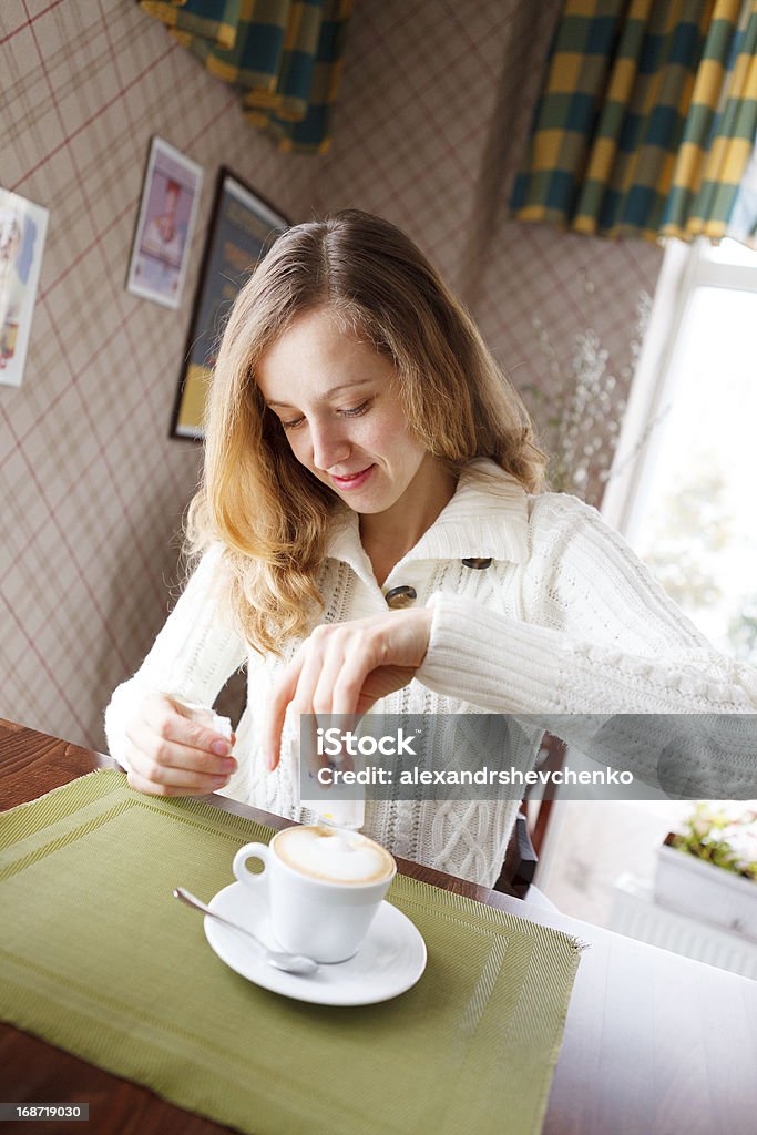 Positive young woman with cup coffee in cafe Positive young woman with cup coffee in cafe. Coffee-break Adult Stock Photo