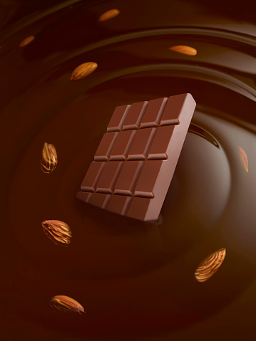 Chocolate bar and almonds coming out of liquid chocolate
