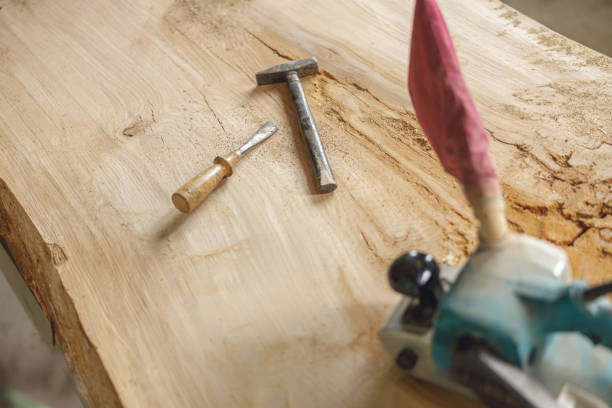 istock Professional electric sander, chisel and hammer is lying on wooden plank in carpentry workshop 1687197842