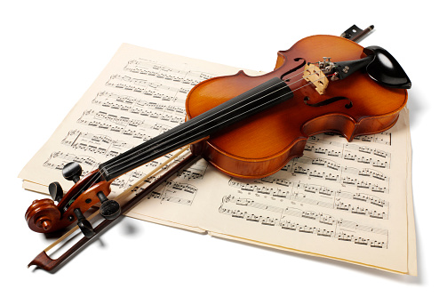 Wooden violin and bow on sheet music, isolated on white with  clipping path 