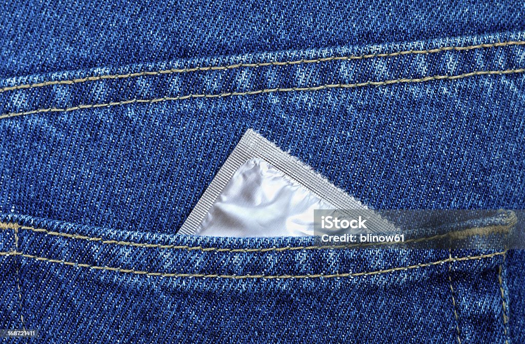 Préservatif de la poche arrière d'un jeans bleu - Photo de Adolescence libre de droits