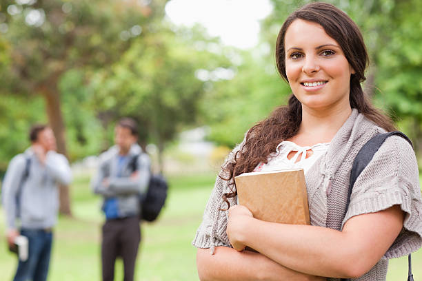 istock Portrait of smiling brunette holding textbook 168722604