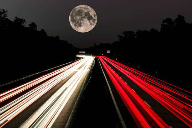 Car light trails and full moon. Lights on the highway. Traces of cars. Abstract light, Lichtschweife. Highway at night and lots of traffic. Car light trails. Lights on the highway. Traces of cars. Abstract light, Lichtschweife. Highway at sunset and lots of traffic. Highway at night. German Autobahn A5. red full moon stock pictures, royalty-free photos & images