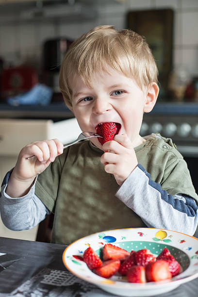 istock Little boy eating fresh strawberries 168723368