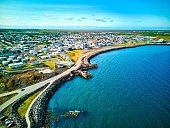 an aerial photo of a city on the ocean side with its beach: Keflavik, Iceland