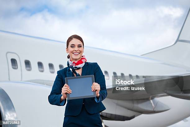 Beautiful Air Stewardess With A Digital Tablet Stock Photo - Download Image Now - Digital Tablet, Air Stewardess, Holding