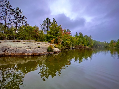 Morning on the Prairie River Grand Rapids Minnesota. Trees and boulders reflecting in clear blue water.