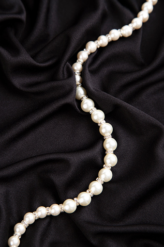 woman wearing pearl diamond necklace and wristband on white background