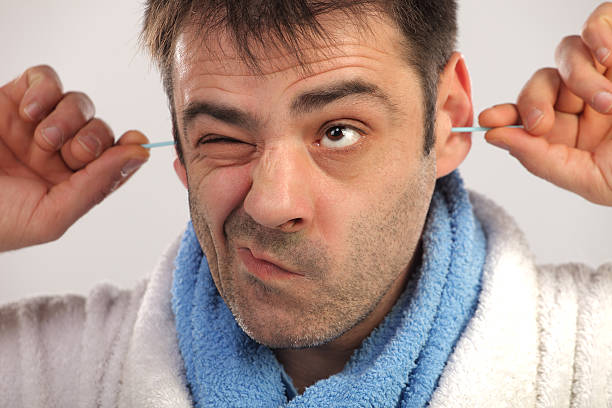 Man cleaning his ears with cotton swab