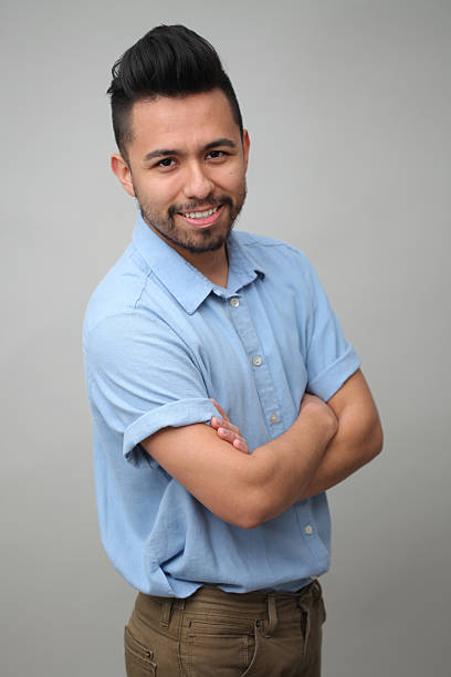 Young Mexican Male Studio Portrait Young guy smiling with his perfect smile. Wearing a blue short sleeve button up shirt. high school photos stock pictures, royalty-free photos & images