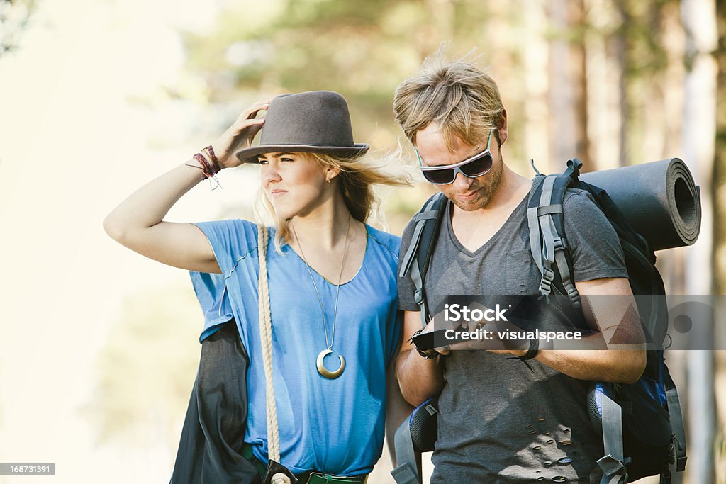 Jeunes branchés de randonnée et à l'aide d'un téléphone mobile intelligent - Photo de A la mode libre de droits