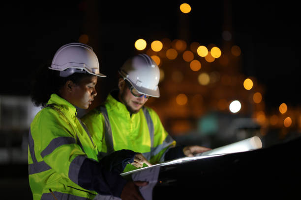 istock A portrait of two system engineers with green safety jackets read the drawing while working on the hood of the car at night 1687319445