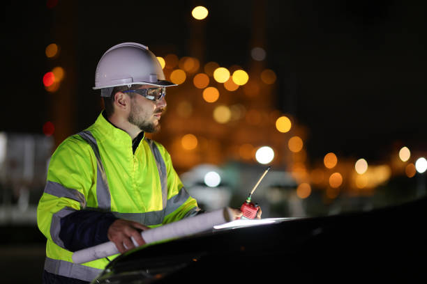 istock A portrait system engineer with a green safety jacket holds the drawing working on the hood of a car and using a walkie  talkie in a front factory on night shift 1687319452