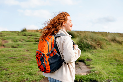 amazed Woman in jacket reaching the destination and taking selfie and shouting on the top of mountain at sunset. Travel Lifestyle concept The national park Peak District in England