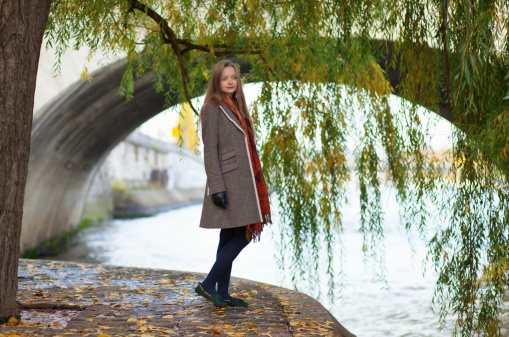 Beautiful young woman near a willow tree