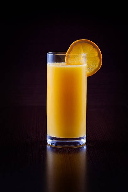 Orange juice isolated on black Orange juice isolated on black background vibrant color lifestyles vertical close up stock pictures, royalty-free photos & images