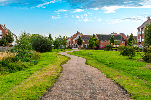 Sidewalk with nicely manicured landscape and brick houses in England