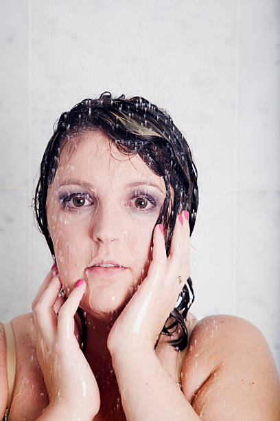 Vulernable Young woman vulnerable in the shower shower women falling water human face stock pictures, royalty-free photos & images