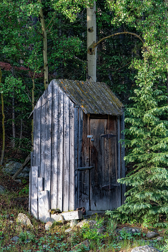 Outhouse in the forest at ghost town in central Colorado in western USA of North America. Nearest cities/towns are St Elmo, Buena Vista, Leadville, Denver, Colorado Springs, Colorado.