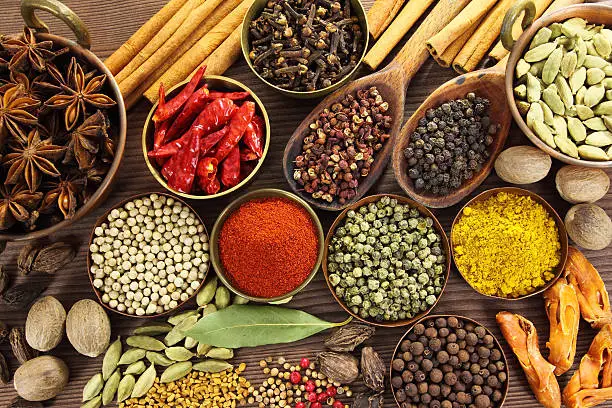 Spices and herbs in metal  bowls and wooden spoons. Food and cuisine ingredients.