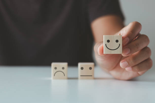 istock Customer service evaluation experience and satisfaction feedback review survey concept. positive, good. Customer's hand choose the happy face smile face and blurred sad face icon on wood cube. 1687430420