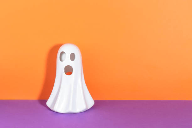 istock Ghost figure with copy space for halloween message on purple and orange background 1687437405