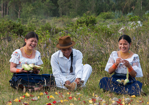 Meeting of 3 indigenous friends in the jungle of Ecuador, young people from Latin America with traditional dresses smiling and laughing intensely. Hispanic heritage month. High quality photo