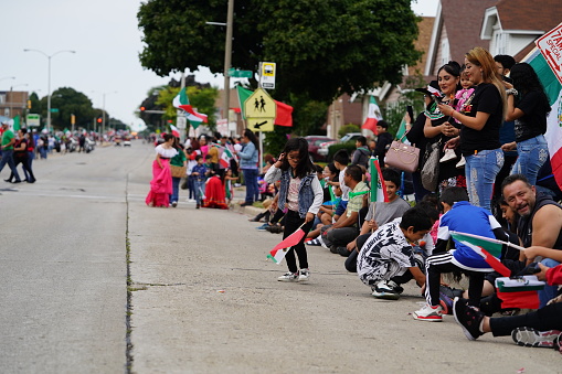 Milwaukee, Wisconsin USA - September 16th, 2023: Latino American families gathered along the streets to watch and spectate the Mexican Independence Day Parade.