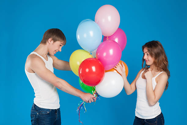 istock smiling young love couple holding balloons in the studio 168760672