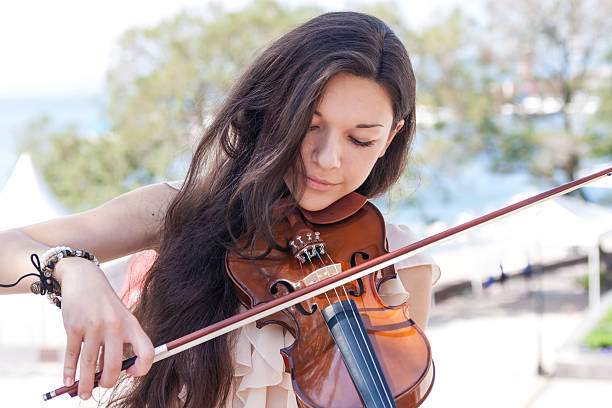 Pretty young female playing the violin, soft focus.