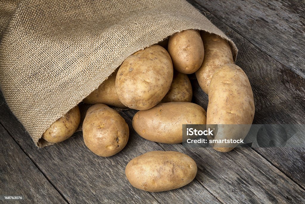 Batatas Russet Spilling de Aniagem de Cânhamo bolsa - Foto de stock de Batata Russet royalty-free
