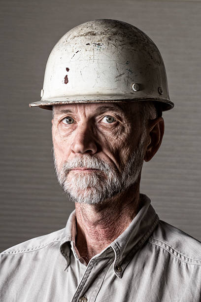 senior maschile operaio edile con elmetto da cantiere - construction dirt dirty manual worker foto e immagini stock