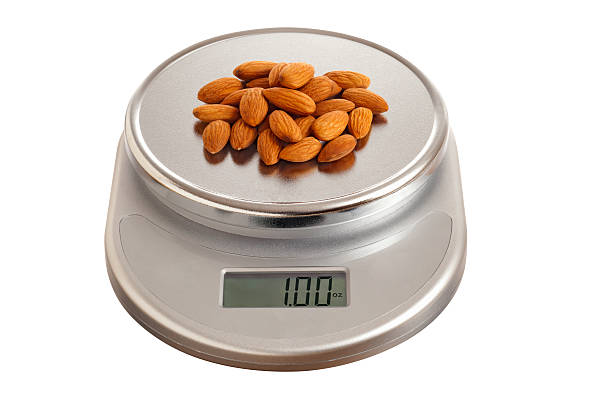 un soupçon d'amandes sur une balance de cuisine - serving size weight scale scale food photos et images de collection