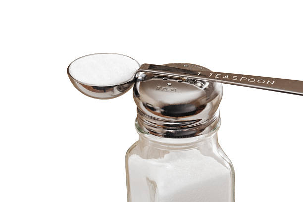 Teaspoon of Salt the Maximum Recommended Daily Intake for Adults Teaspoon of salt resting on the top of salt shake. This is the recommended amount of sodium intake is less than one teaspoon healthy adults. Isolated on white with clipping path included. teaspoon stock pictures, royalty-free photos & images