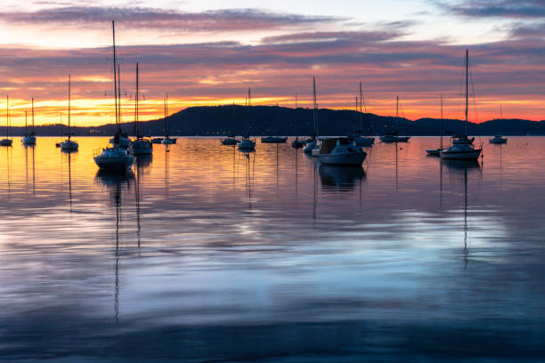 istock Sunrise over the water with boats, reflections and high cloud 1687694792
