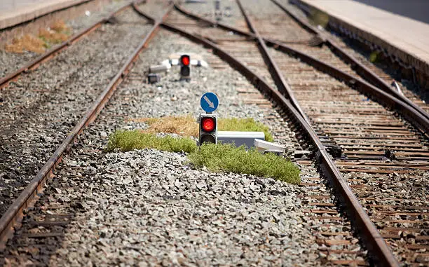 Old rails and traffic lights on red at old railway station