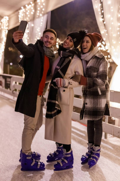 istock Three joyful young friends taking selfies while ice skating at the ice rink 1687708157