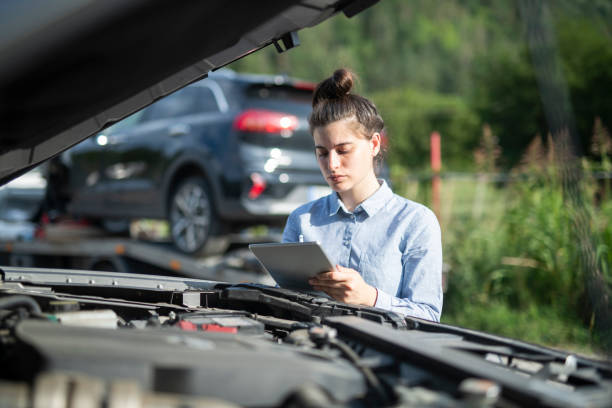 On site inspection.Insurance agent inspecting vehicle damage. Female insurance agent using digital tablet to inspect and write down vehicle damages. broken digital tablet note pad cracked stock pictures, royalty-free photos & images