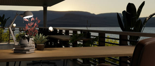Copy space on a wooden table on a spacious balcony with a beautiful mountain and lake view at night.