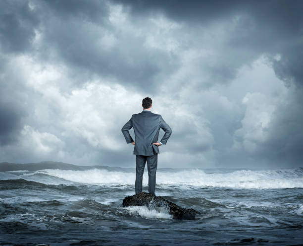 istock Businessman Standing In Rough Ocean Surf 1687716975