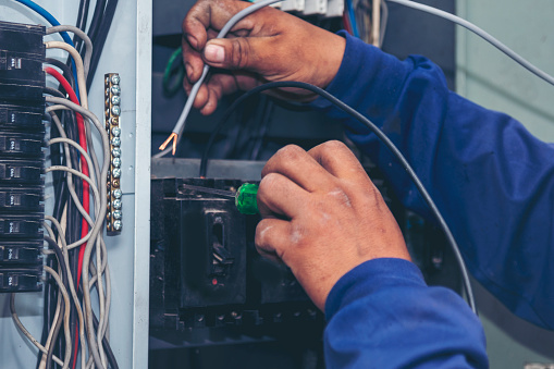 Electrical mechanic technician check wire electric cabinet. Inspector men hands working switchboard machinery maintenance service. Electrician circuit repair voltage operation. Men hands fix breaker