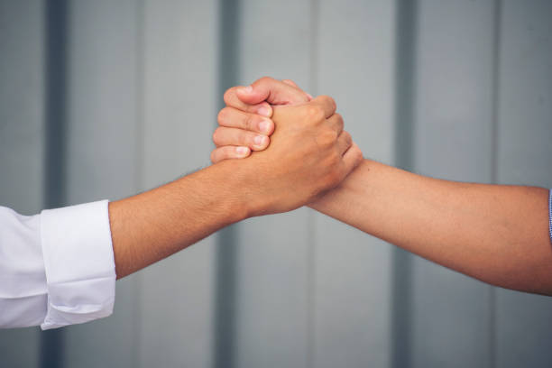 istock Close up warehouse worker shakehand together. Engineer man hands partnership. Diversity Coworker Men logistics Warehouse teams handshake. Multiracial Support team greeting person teamwork colleagues 1687728531