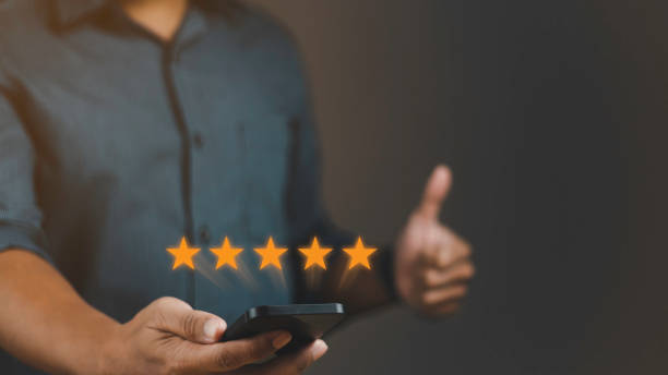 istock Customer review satisfaction feedback survey concept. User give rating to service experience on online application. Man using smartphone with five stars and showing thumbs-up. 1687730506