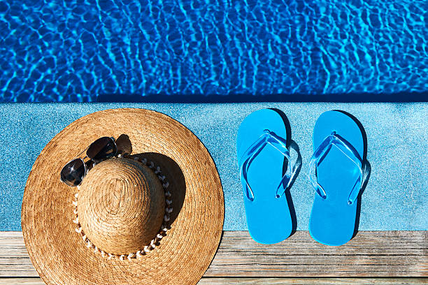 istock Blue slippers and hat by a swimming pool 168773586