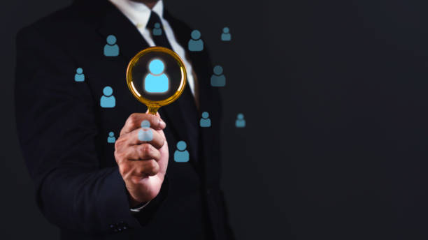 istock Businessman using magnifying glass search quality people against dark background. 1687756142