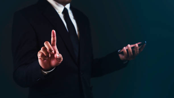 istock Businessman is using smartphone and pointing or touching for choose something against dark blue background. 1687761452